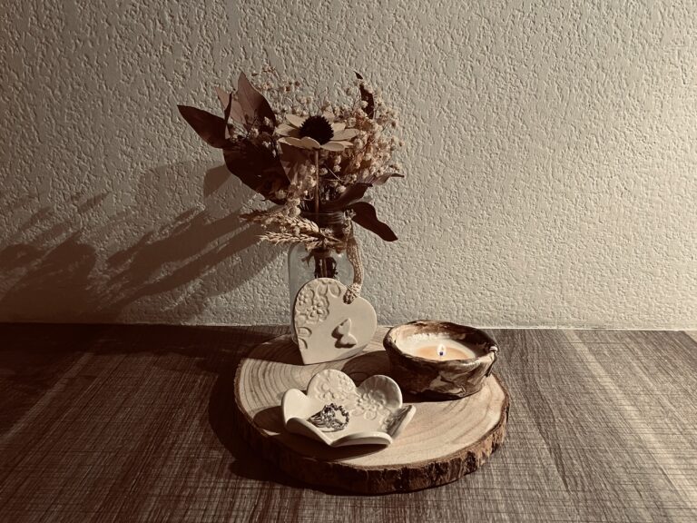 1 bougie allumée en terre mêlée, une coupelle fleur dentelles et un coeur déco à suspendre