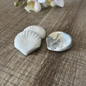 3 Coquillages en céramique bleu et blanc posé sur un plan de travail marron